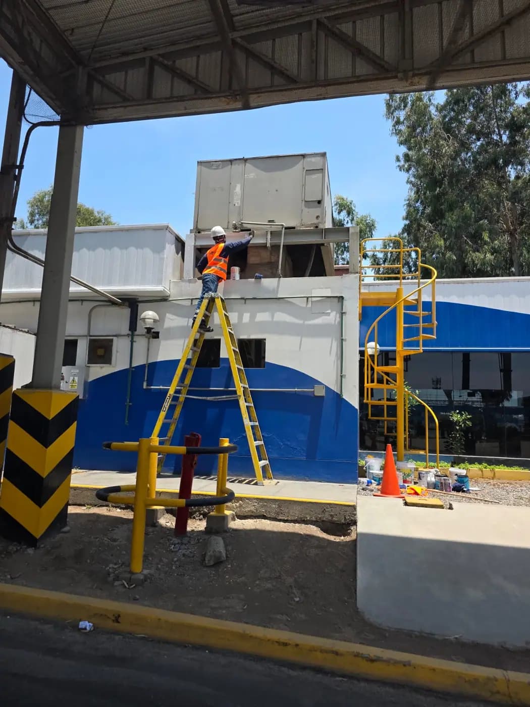 Técnico trabajando en altura sobre una estructura en planta industrial